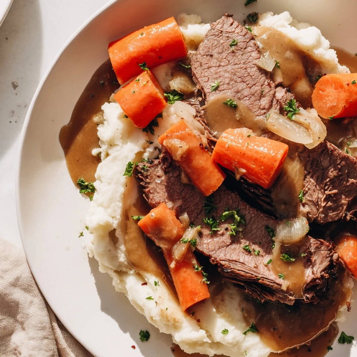 Hearty American dinner: comforting Slow Cooker Pot Roast boasting succulent beef and buttery mashed potatoes.