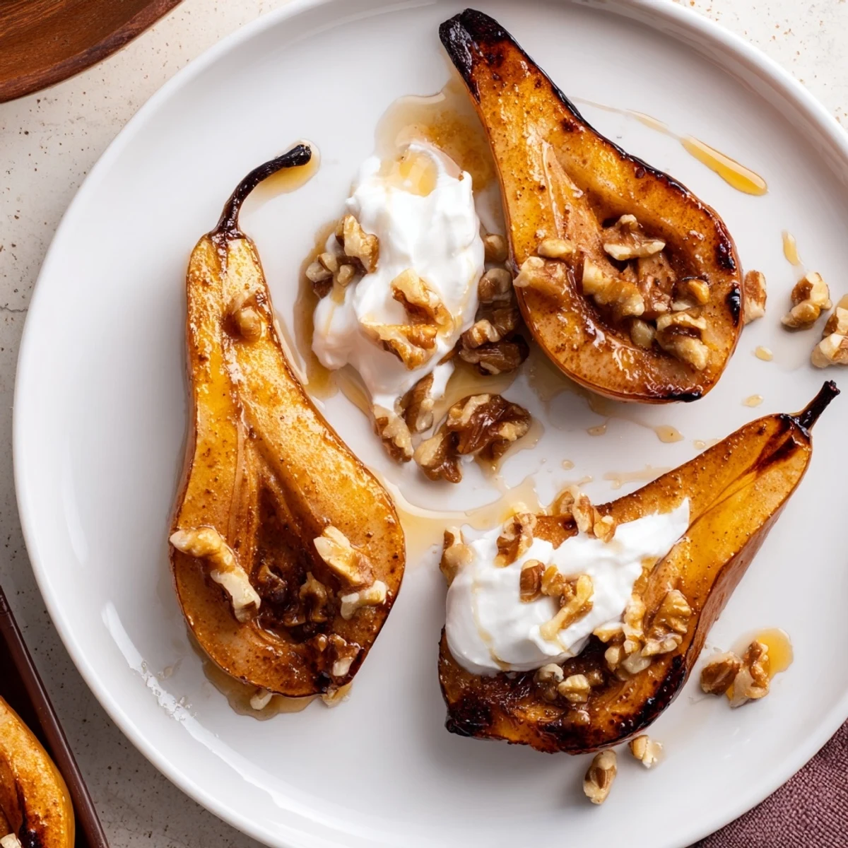 Warm roasted pears with cinnamon, walnuts, and Greek yogurt, perfect for a cozy dessert.