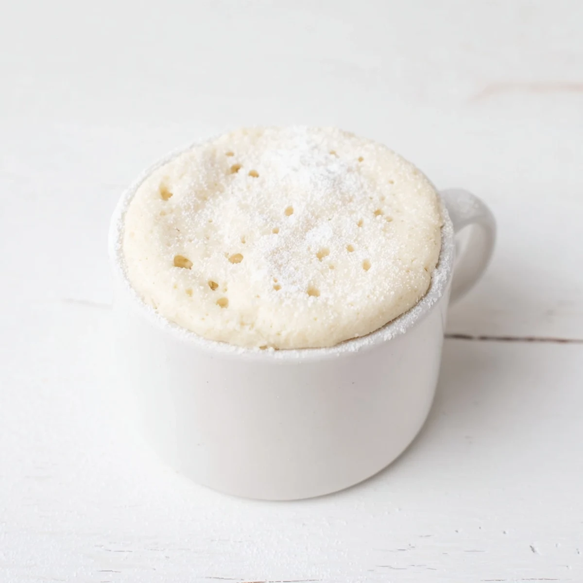 Fluffy microwave mug cake, ready in minutes, served warm with a scoop of vanilla ice cream.