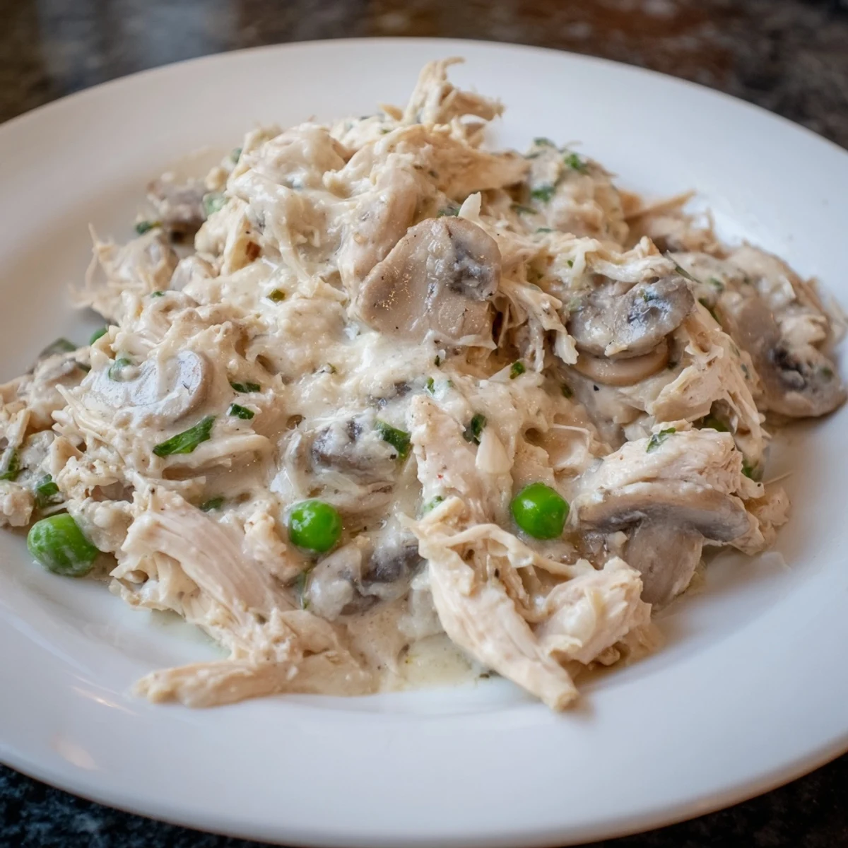 Golden, slow-cooked Creamy Chicken Alfredo, ready to serve over steaming hot pasta for dinner.