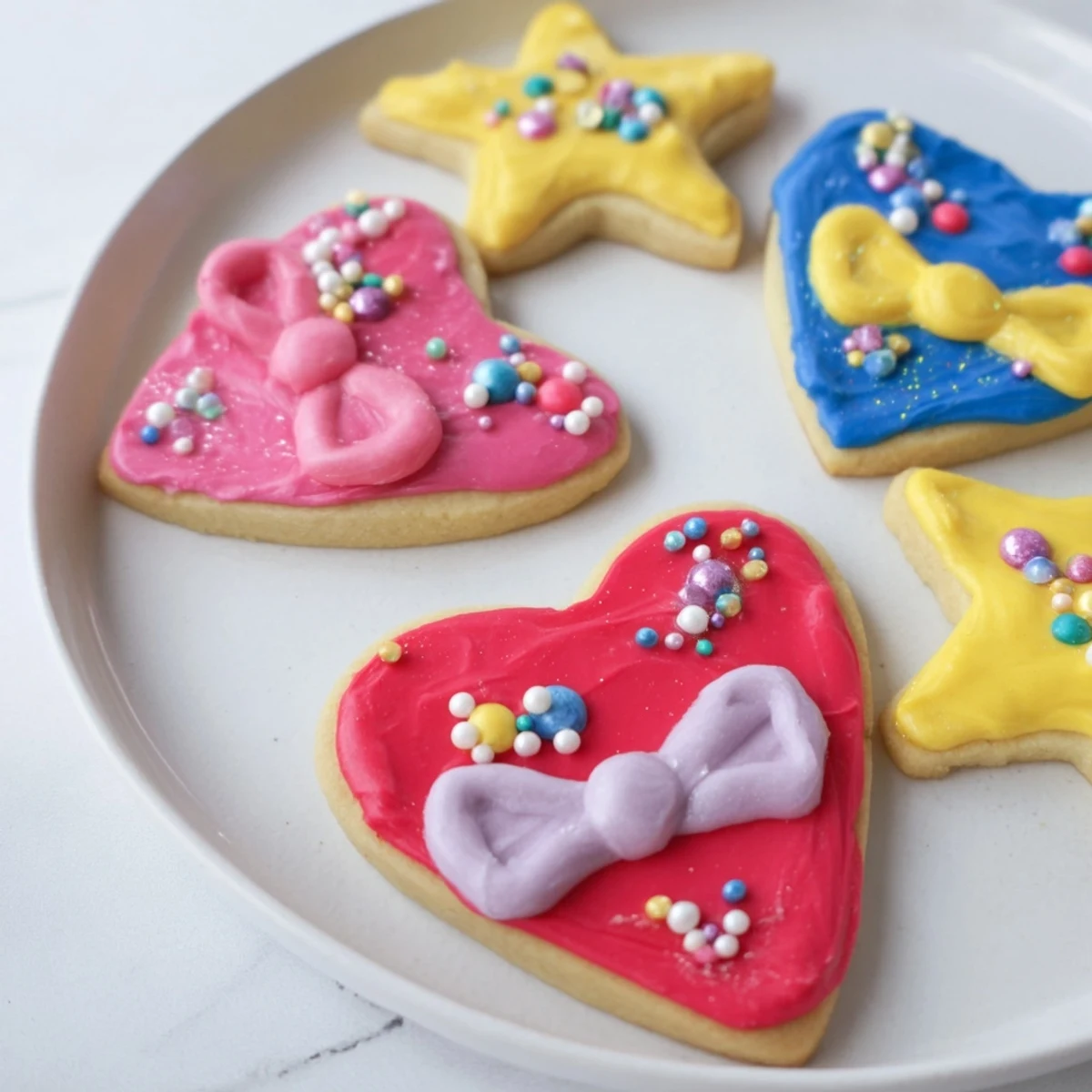 Pretty Bows Heart & Star Cookies: Colorful icing decorates charming heart and star shaped sugar cookies, ready to be enjoyed.
