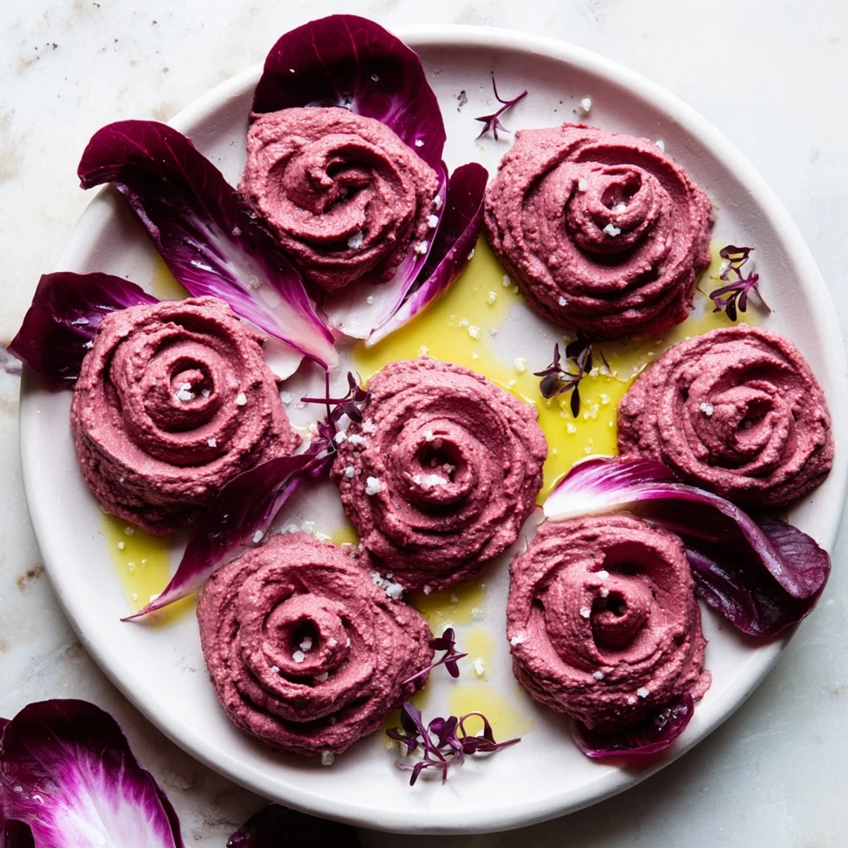 Vibrant swirled rose-shaped The Velvet Rose appetizer, beet hummus, and crisp radicchio leaves, ready to enjoy.