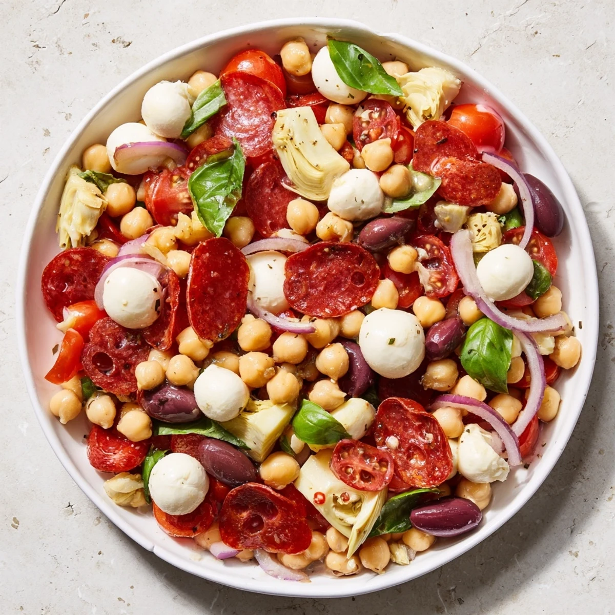 Vibrant Antipasto Chickpea Salad overflowing with colorful veggies, mozzarella, and a tangy Italian dressing.