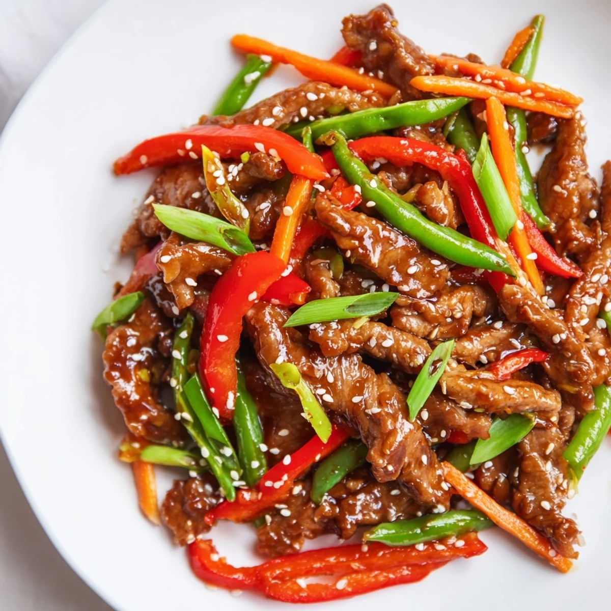 Sweet teriyaki pork stir-fry, glistening with a savory sauce, served over fluffy white rice.