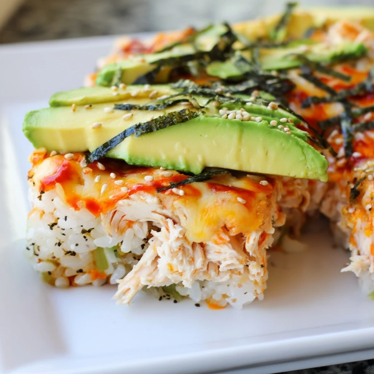 Savory Chicken Sushi Bake with melted cheese, sesame seeds, and a flavorful chicken layer.