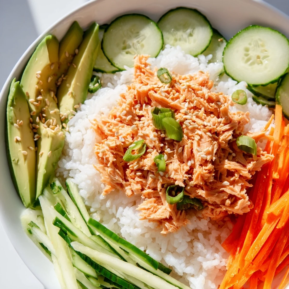 Steaming Spicy Canned Salmon Rice Bowl topped with fresh veggies, a flavorful and easy meal.