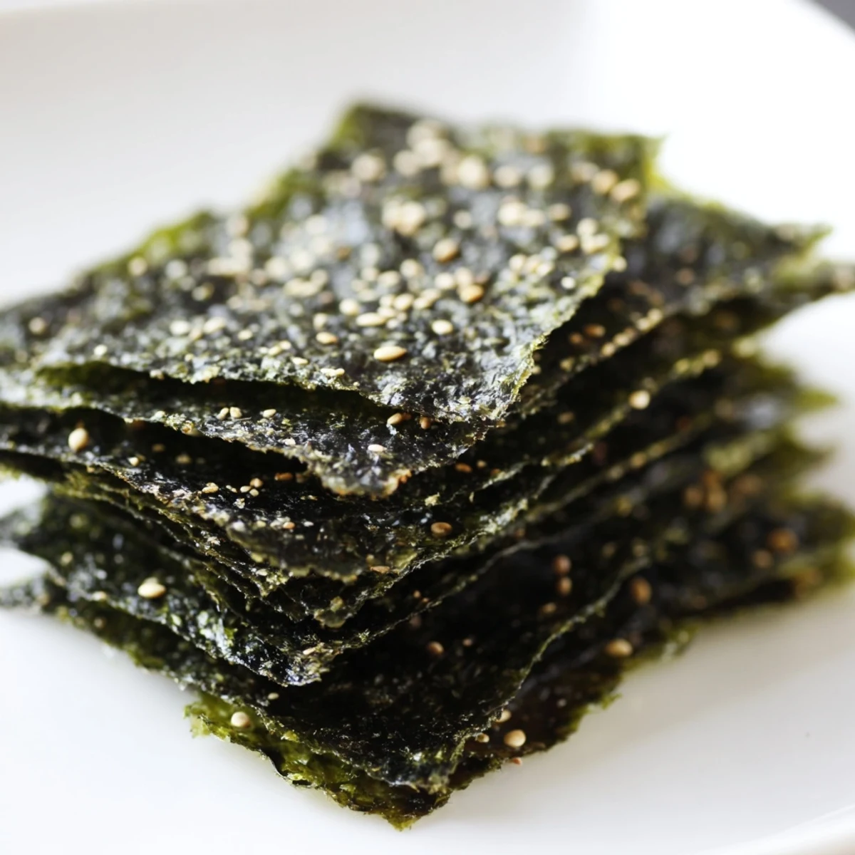 Crispy roasted seaweed chips stacked high, seasoned with salt and sesame oil for a savory, light snack.