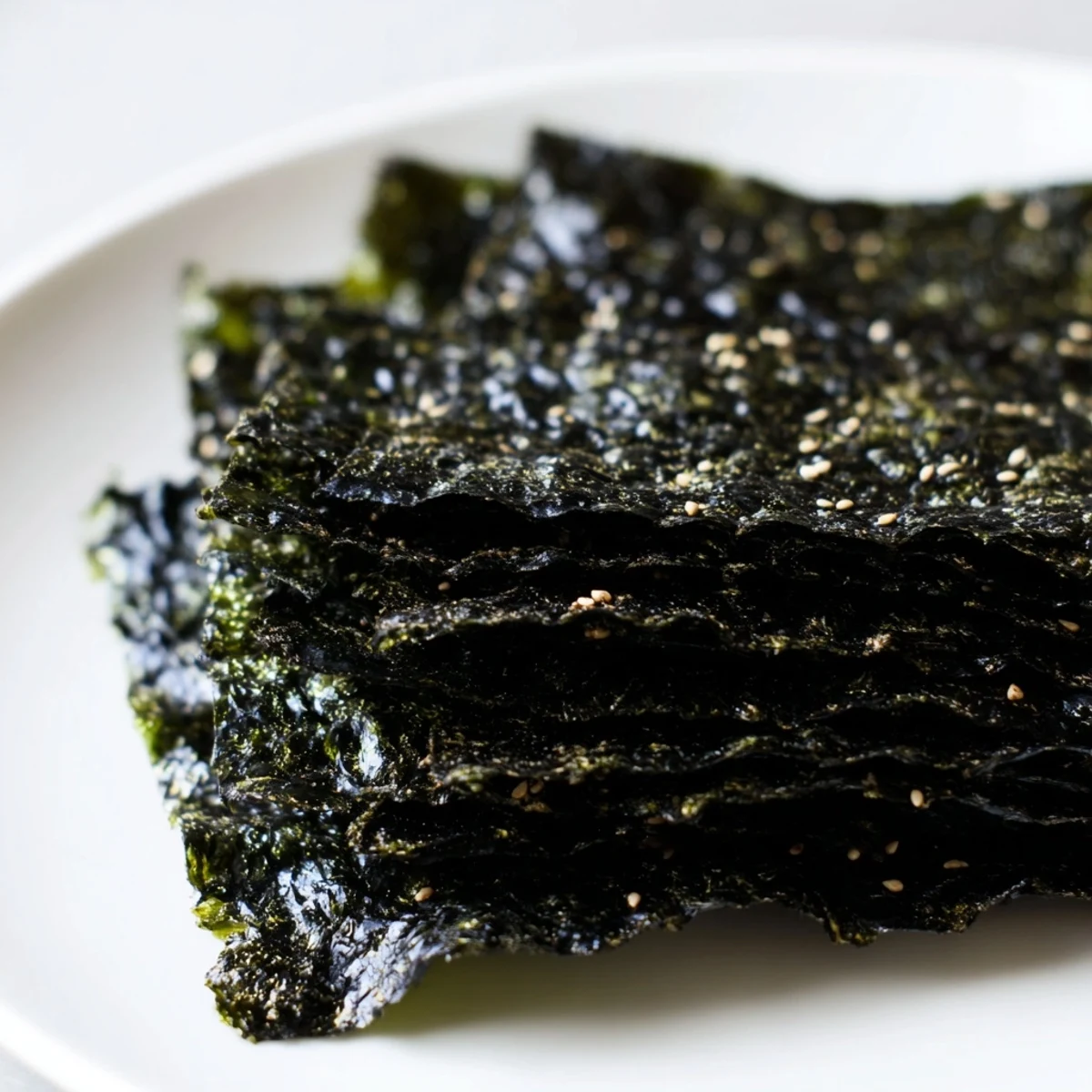 Roasted seaweed chips arranged on parchment paper, golden green and crunchy, perfect for vegan snacking.