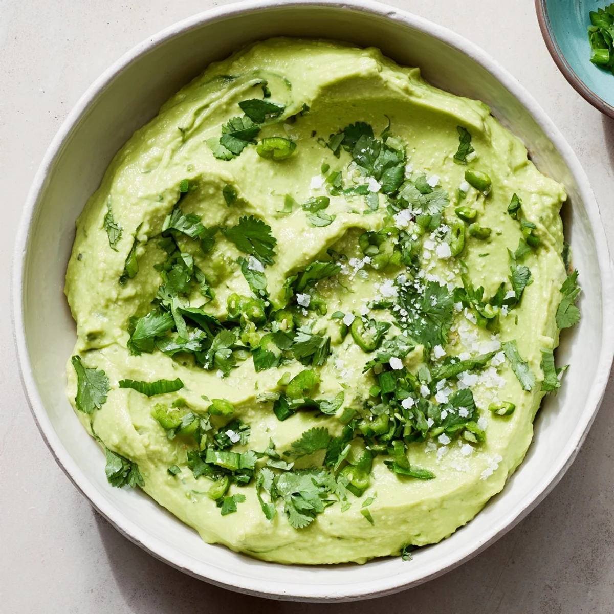 Easy homemade avocado lime dip in a white serving bowl, ready to enjoy with tortilla chips or as a taco topping.