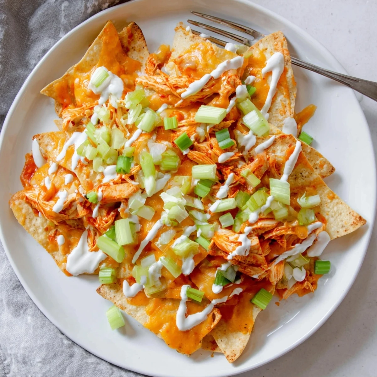 Fresh green onions and celery garnish these hot Buffalo Chicken Nachos ready for game day.