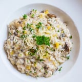 A close-up of delicious risotto with mushrooms, garnished with fresh parsley and Parmesan.