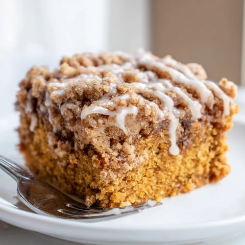 Moist pumpkin spice coffee cake adorned with cinnamon streusel, perfect for brunch.  