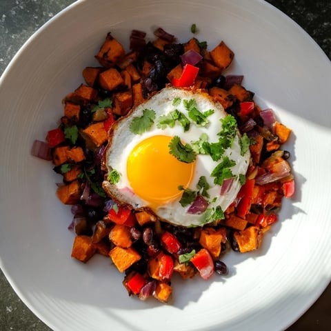 Golden-brown Sweet Potato & Black Bean Breakfast Hash, topped with perfectly poached eggs, ready to enjoy.