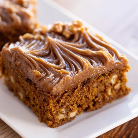 Warm pumpkin bars with rich brown sugar frosting, a decadent autumnal dessert.