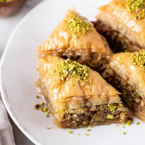 Golden, flaky Turkish Baklava glistening with sweet honey syrup, showcasing its layers of nuts.