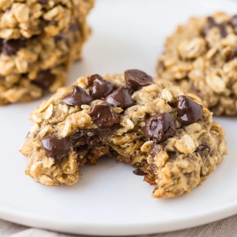 A close-up of soft, chewy Oat-Banana Chocolate Chip Cookies, studded with melting chocolate chips.