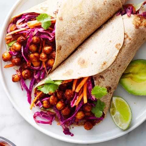 Freshly assembled BBQ Chickpea & Slaw wraps, showcasing layers of crunchy slaw and creamy avocado.