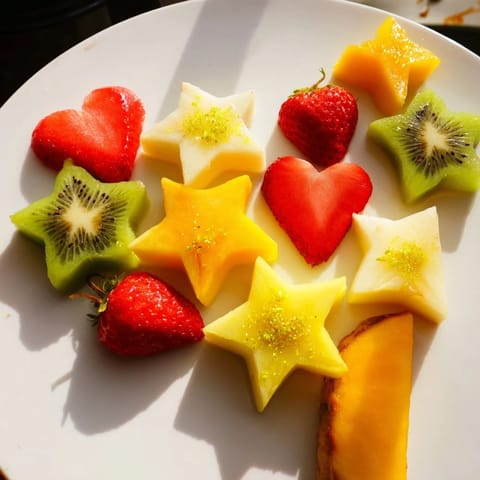 Vibrant kiwi, strawberry, and mango cut into Midnight Kiss Star & Heart garnishes for cocktails.