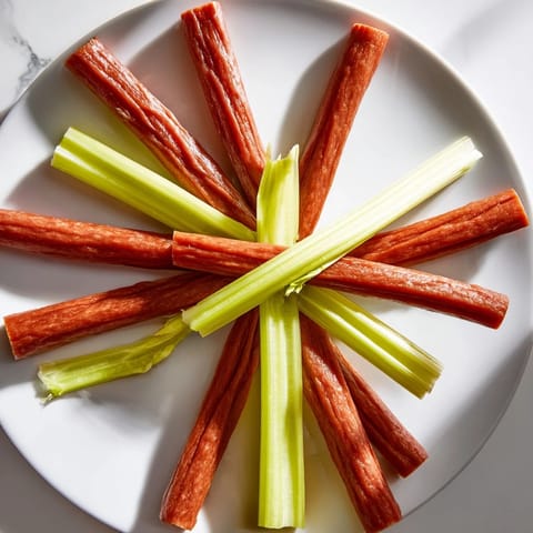 This simple, stunning rustic wheel appetizer offers a perfect shareable snack with alternating celery and meat sticks.
