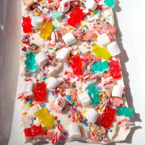 Chewy gummy bears and crushed candy canes atop creamy white chocolate; a delicious party snack recipe.
