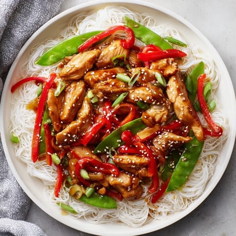 Close-up of a flavorful Mongolian Chicken dish, showcasing the vibrant veggies and perfectly cooked noodles.