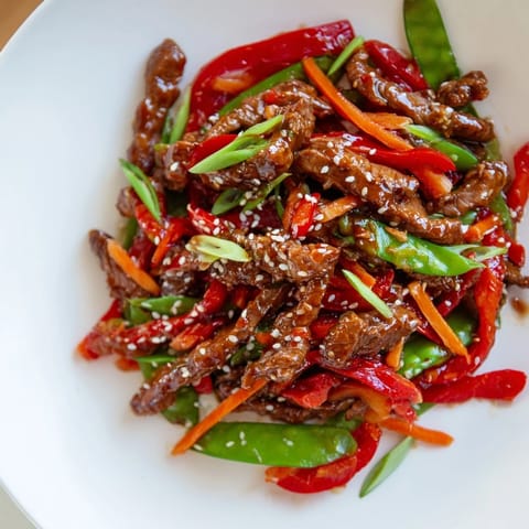 Enjoy a steaming bowl of sweet teriyaki pork stir-fry, full of colorful vegetables and tender meat.