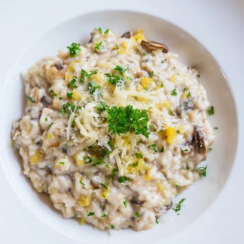 A close-up of delicious risotto with mushrooms, garnished with fresh parsley and Parmesan.