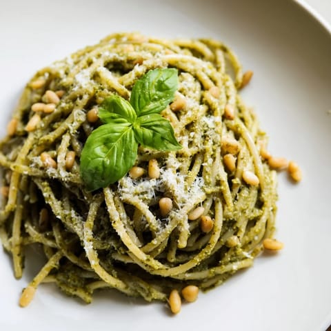 Creamy sunflower seed pesto pasta twirled on a fork, revealing the rich green sauce and tender noodles perfect for a vegetarian dinner.
