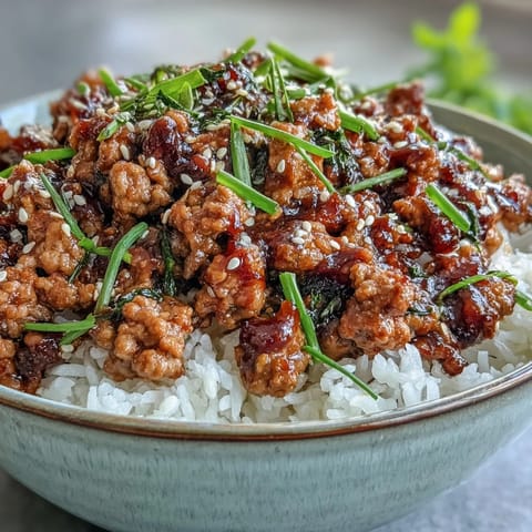 Ground turkey is cooked with garlic and ginger, simmered in a savory soy sauce, and garnished with toasted sesame seeds.