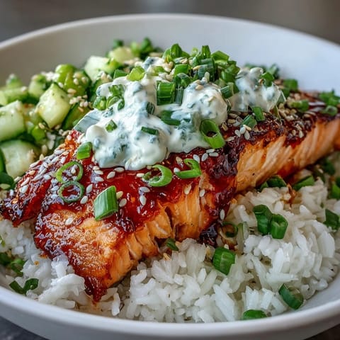Flaky, oven-baked salmon rests on warm rice, loaded with crisp cucumber and edamame salsa, finished with sesame seeds and tangy lime wedges for serving.