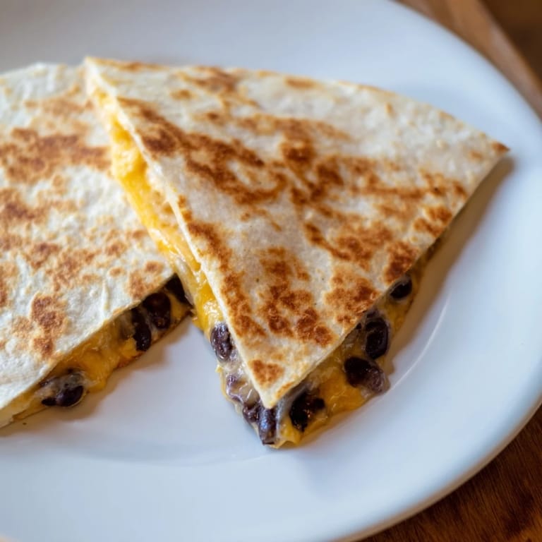 A stack of delicious quesadillas featuring melty cheese and savory beans, quick and easy to prepare.