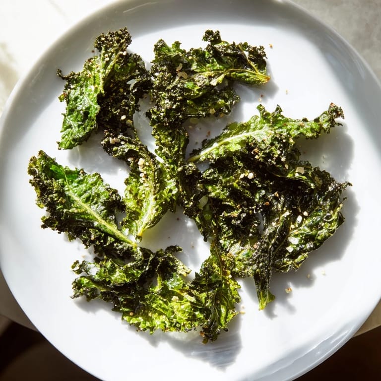 Enjoy a close-up of perfectly seasoned and baked homemade Kale Chips, a gluten-free American snack.