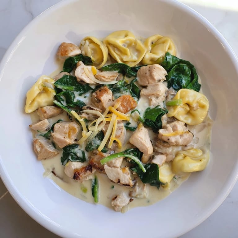 This photo features a luscious Creamy Chicken and Spinach Tortellini ready to be served and enjoyed immensely.