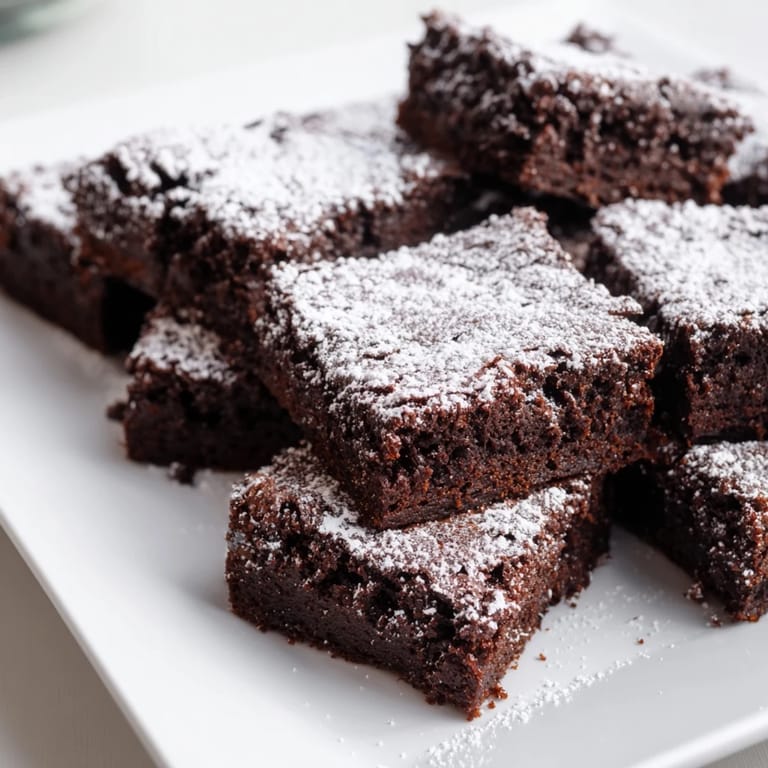 Close-up of freshly baked brownie squares, showing a classic American treat with sweet dusting.