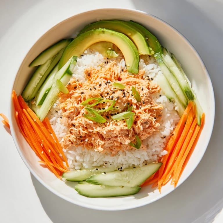 Flaky salmon glistens atop a Spicy Canned Salmon Rice Bowl, a quick and satisfying dinner option.