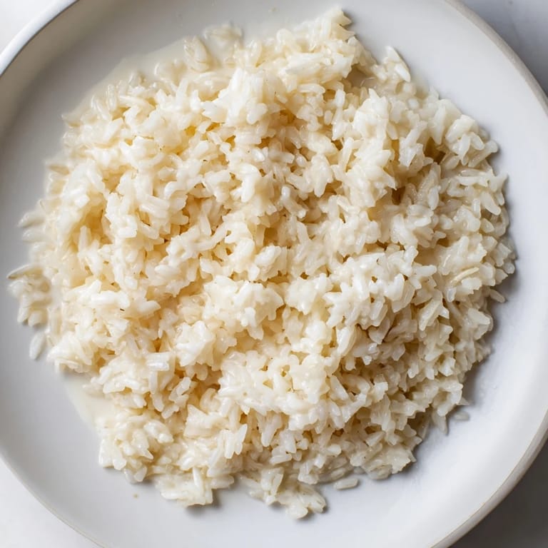 A bowl of creamy Coconut Jasmine Rice, with glistening grains, ready for a flavorful bite.