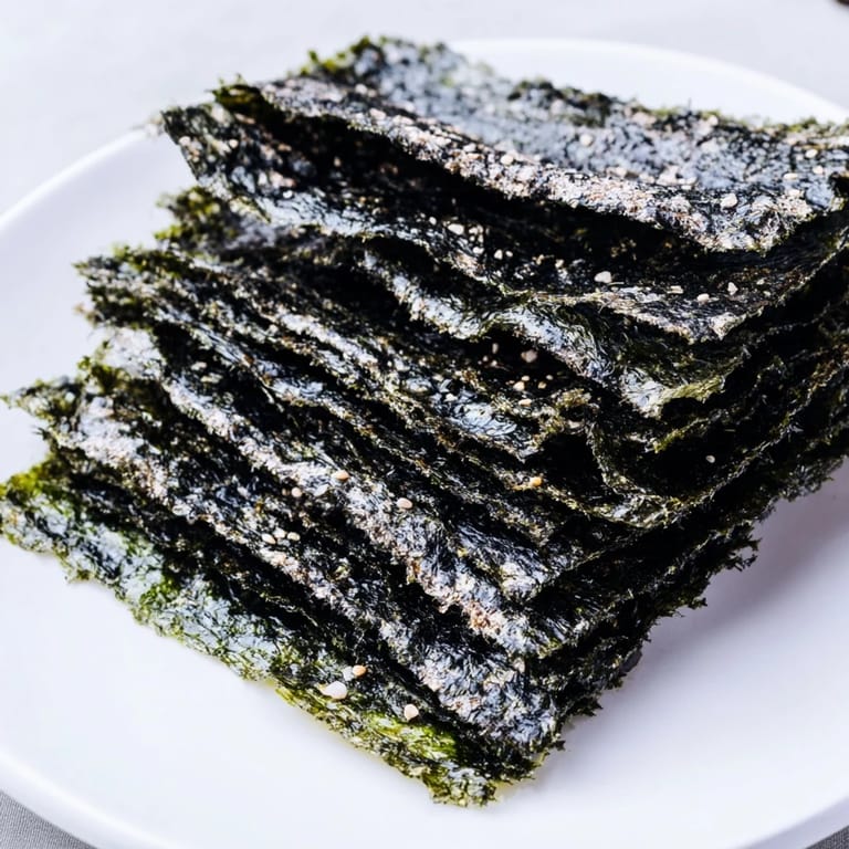 Homemade roasted seaweed chips lightly brushed with sesame oil, offering a crisp, salty bite in each piece.