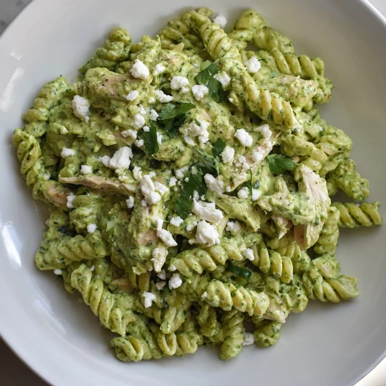 Cilantro lime chicken pasta served warm with rotini, tender chicken, and zesty yogurt sauce, plus lime wedges.